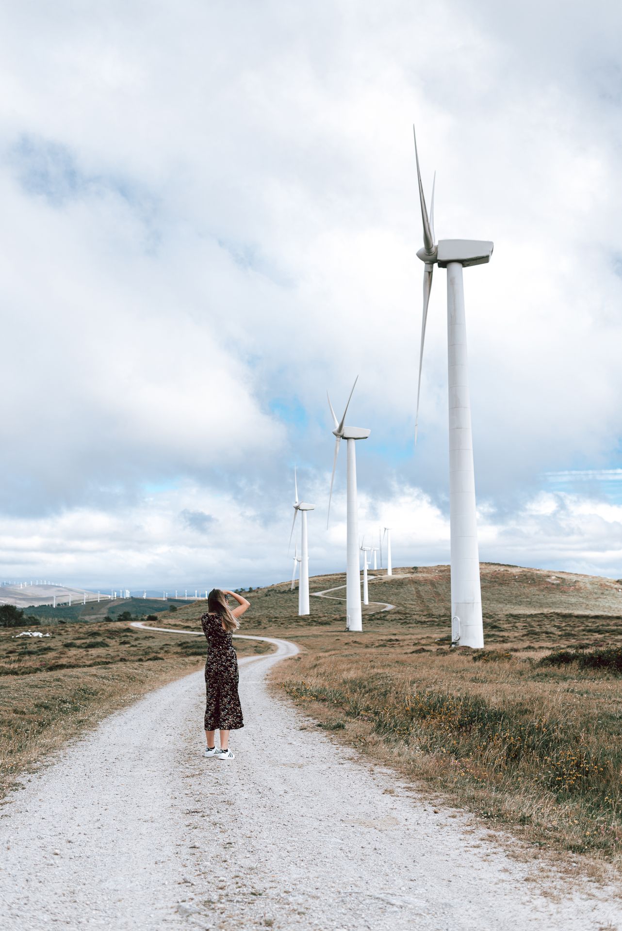 woman-taking-photos-on-a-wind-turbine-farm-2024-12-01-18-46-18-utc_lite